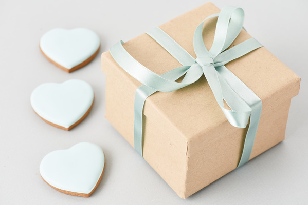 Gift with Blue Bow is Next to Heart-Shaped Gingerbread
